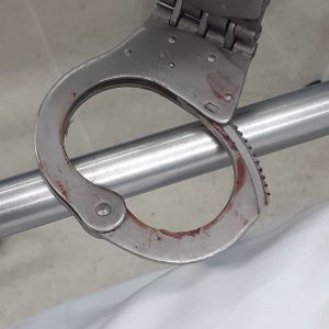 Homem usa sangue para se soltar de algema, quebra teto de hospital, cai em cima de paciente e pula janela